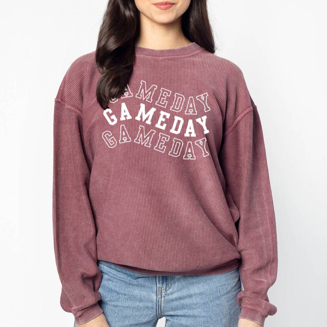Person wearing a maroon 'GAMEDAY' sweatshirt on a white background
