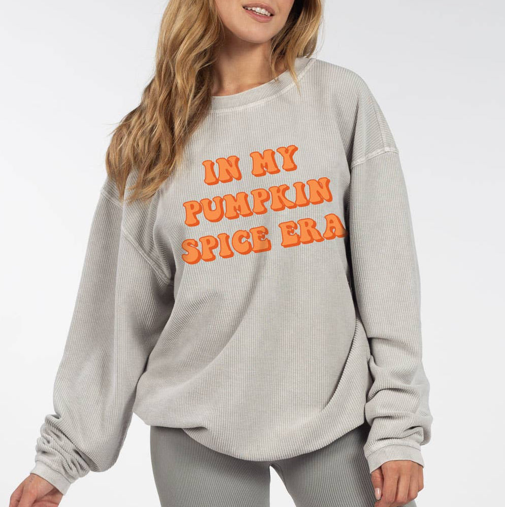 Woman wearing a gray sweatshirt with orange text and gray shorts on a white background